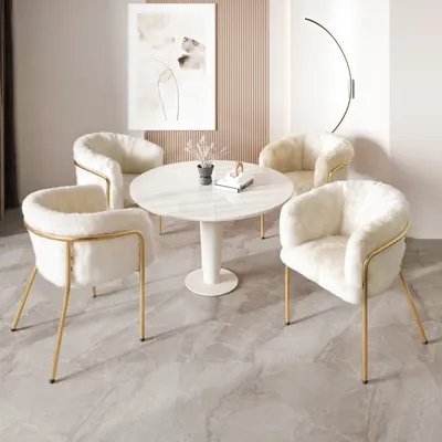 A round dining table with four chairs in a dining room setting.