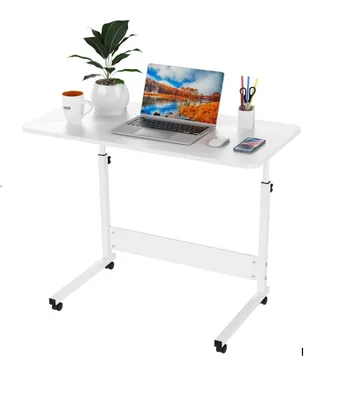 A white adjustable laptop table with a laptop, plant, mug, and pens on it, set against a white background.