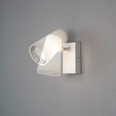A modern wall lamp with two adjustable spotlights is mounted on a textured gray wall.