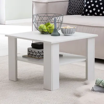 A white coffee table with decorative items on top and storage on the shelf, placed in a living room setting.