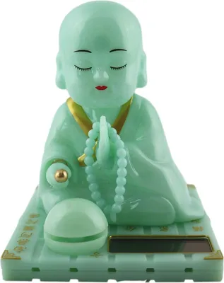 A solar-powered Wackelfigur (bobblehead) of a green Buddha monk.