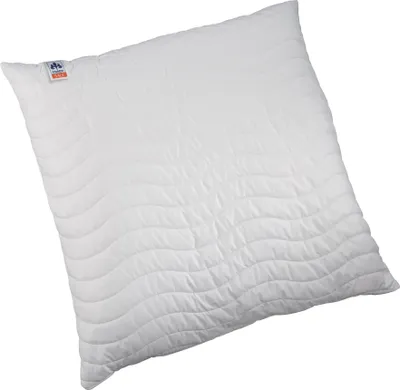 A white pillow with a wave-like quilted pattern.