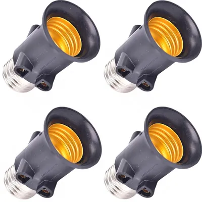 Four black light bulb socket extenders with gold-colored interiors are arranged in a grid pattern against a white background.