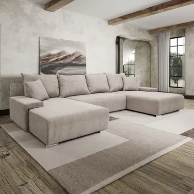 A spacious living room with a large U-shaped sofa, a painting on the wall, and wooden beams on the ceiling.