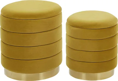 Two round, mustard yellow velvet ottomans stacked with gold bases against a white background.