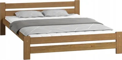 A wooden bed frame with a mattress, duvet, and pillows.