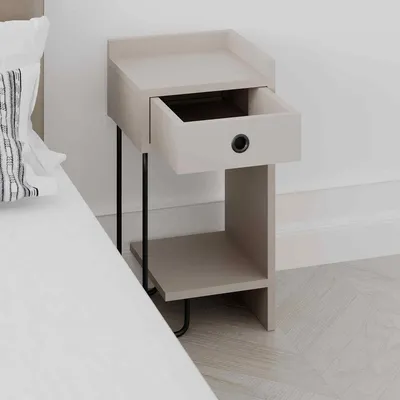 A modern bedside table with an open drawer, placed next to a bed.