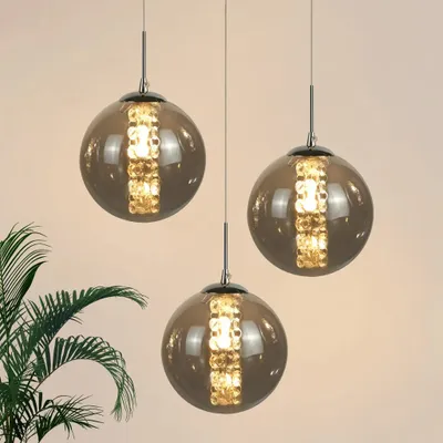 Three glass pendant lights with gold accents hanging against a light background.