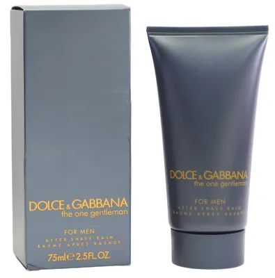 Dolce & Gabbana The One Gentleman After Shave Balm in dunkelgrauer Tube mit goldener Schrift, stehend neben passender Verpackung