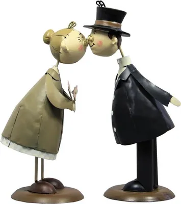 Two decorative figures of an elderly couple kissing, dressed in formal attire.