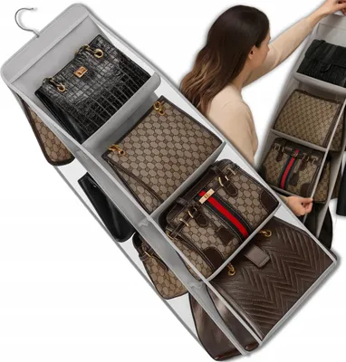 A woman is organizing handbags in a hanging closet organizer.