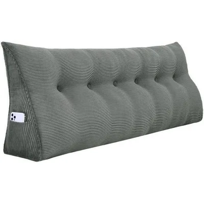 A gray wedge pillow with a ribbed texture and button tufting, shown against a white background. A smartphone is visible in a side pocket.