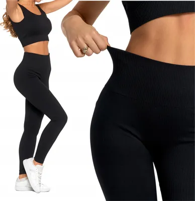 A woman wearing black leggings and a sports bra, with a close-up view of the leggings' waistband.