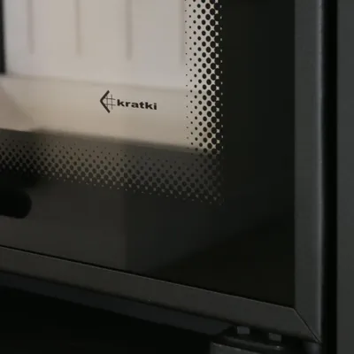 A close-up view of a fireplace insert with a logo on the glass.
