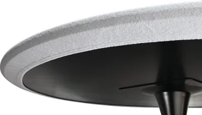 A close-up view of the underside and edge of a round table with a textured white surface and a black base.