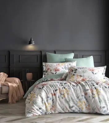 A bedroom scene with a bed dressed in floral bedding.