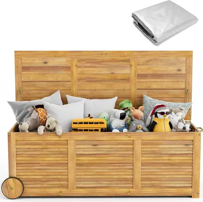 A wooden toy chest filled with stuffed animals and a toy bus, with a tarp folded in the upper right corner.