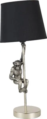 A table lamp with a monkey figure climbing a pole.