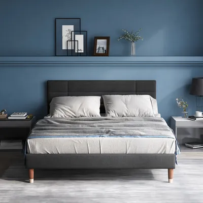 A bedroom scene with a bed, nightstands, and wall decor.