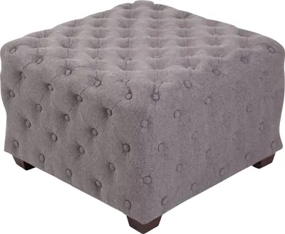 A close-up of a square, tufted ottoman with short wooden legs.