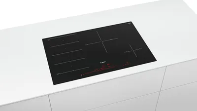 A black induction cooktop is shown on a white countertop.