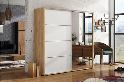 A modern bedroom or dressing area featuring a large wardrobe with mirrored doors, a chair, and decorative items.