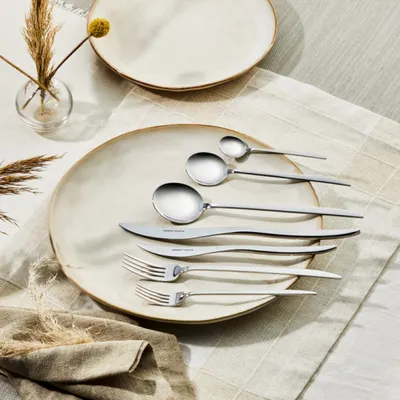 A set of silverware is laid out on a plate and a placemat.