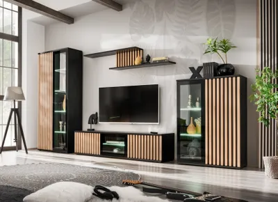 A modern living room with a wall unit, TV, and decorative items.