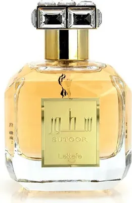 A perfume bottle with a gold label and a crystal-embellished cap.