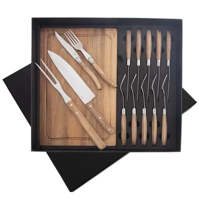 A steak cutlery set with a wooden cutting board and knives, forks, and other utensils, neatly arranged in a black box.