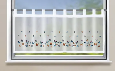 A sheer white curtain with a pattern of colorful butterflies is hung on a window.