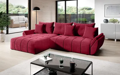 A modern living room with a large L-shaped sofa, a coffee table, and a view of an outdoor patio.