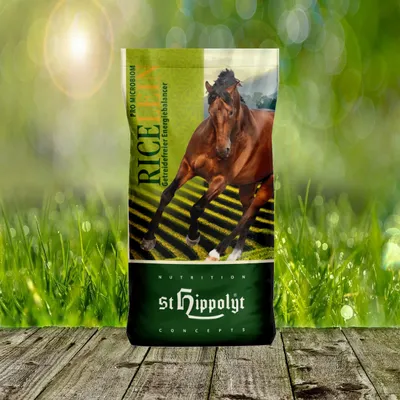 A bag of horse feed with a horse image on it, set against a blurred background of grass and sunlight.