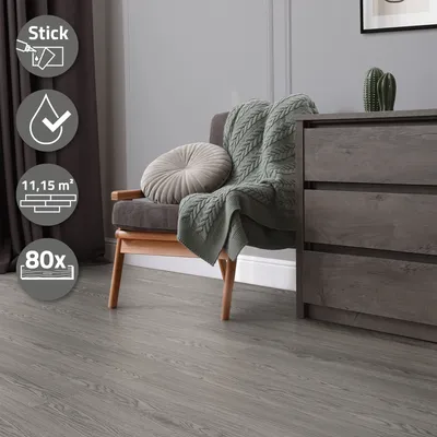 A room interior with a chair, blanket, and dresser, showcasing the flooring.