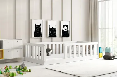 A child's bedroom with a white bed, toys, and artwork on the wall.
