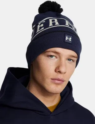 A man wearing a navy blue beanie with white lettering and a black pom-pom.
