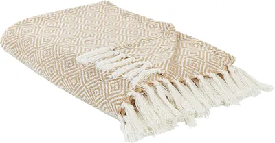 A beige cotton throw blanket with a geometric diamond pattern and white fringes is displayed on a white background.