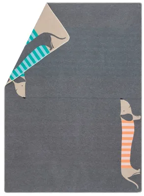 A folded blanket with a dachshund pattern on a gray background.