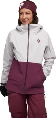 Dame trägt die "W Recon Stretch Ski Shell" Jacke von Black Diamond in Grau und Burgunderrot; mit Kapuze und lächelndem Gesichtsausdruck.