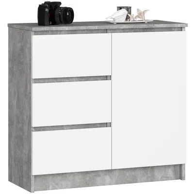A modern white and gray cabinet with three drawers and a door, displayed against a white background. A camera is placed on top of the cabinet.