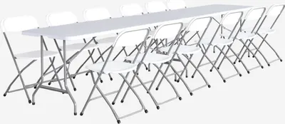 A long white folding table with twelve white folding chairs arranged around it.
