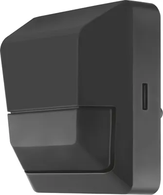 A black motion and light sensor mounted on a wall.