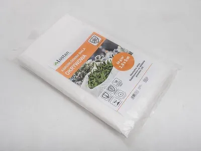 A white agro-textile product is packaged in clear plastic, with a label showing product details and an image of plants.