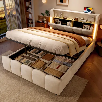 A bedroom scene with a bed that has storage compartments open, showing folded items inside. The bed has a built-in headboard with shelves and lighting.