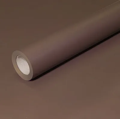 A roll of brown wrapping paper is shown diagonally across a brown surface.