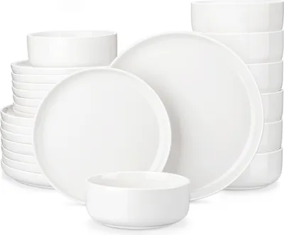 A stack of white ceramic plates and bowls arranged on a white background.