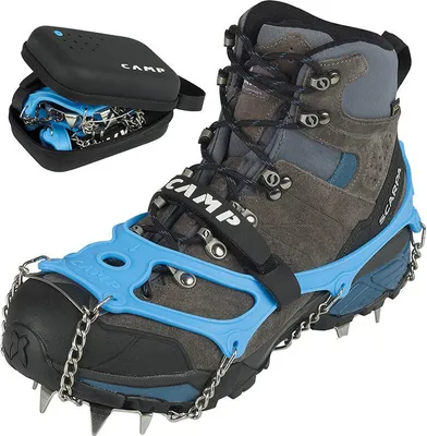 A close-up of a hiking boot with crampons attached, and a carrying case for the crampons.