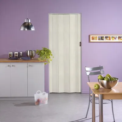 A kitchen scene with a folding door, cabinets, a table, and chairs.
