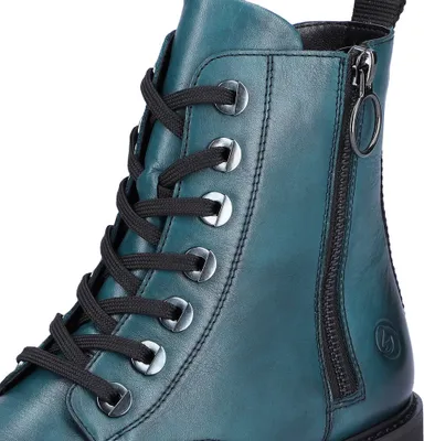 Close-up view of a teal leather boot, showing the lacing and zipper detail.