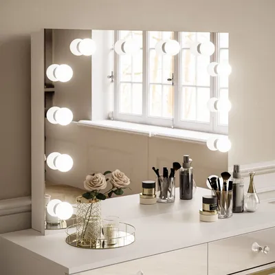 A vanity mirror with lights and makeup accessories on a dresser.